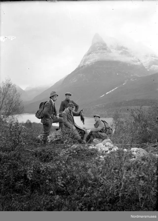 Fire menn på fjelltur/fisketur. Her samlet for å se på dagens fangst. Det er ukjent hvem vi ser på bildet, samt hvor det er tatt. Datering usikker. Fra Nordmøre museums fotosamlinger, Myren-arkivet.
