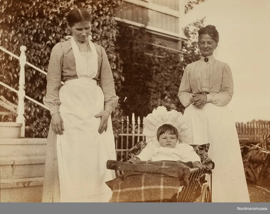to tjenestejenter/barnepiker med et av barna på Ulleberg i Larvik; kanskje Marie selv?
 Bilde fra Marie Knudtzon (1879-1966) sin fotosamling. Se bilde nr KMb-2010-011.0001 for mer biografi. Fra Nordmøre museum sin fotosamling.
