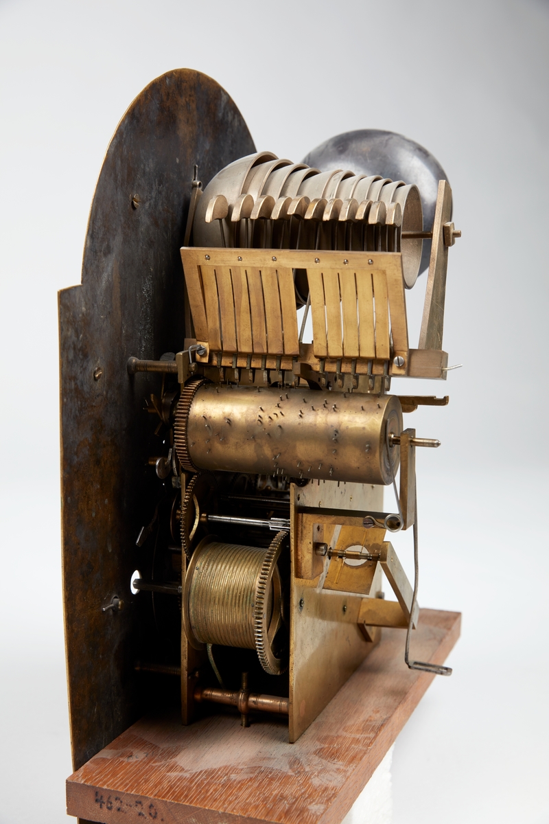 Gulvur i antatt sekundær kasse. Buet toppstykke med brutt gavl og vinduer til urverket på sidene. Rektangulær hoveddel med svungen sokkel nederst. Toppstykket dekorert med utskåret gitterverk øverst samt tre kuler på gesimsen og søyler på hver side av lysåpningen. Hoveddelen av kassen med pendeldøren er udekorert, sokkelen dekorert med utskåret gitterverk samt blader (akantus) på sidene og musling på midten nederst. Hele kassen malt ensfarget rød, kulene på gesimsen er sorte.

Urverk av messing forsynt med spillverk med elleve bjeller (visstnok til to melodier) samt én timeslagbjelle. Støpt dekor i tallskivens hjørner, hovedsakelig bladverk og c-formede ornamenter i et intrikat mønster. Midtfeltet er finhamret uten annen ornamentikk. Forsølvet timering og stjerneformet sekundring samt navneplate med signatur øverst og datoring som vises over sekstallet nederst.