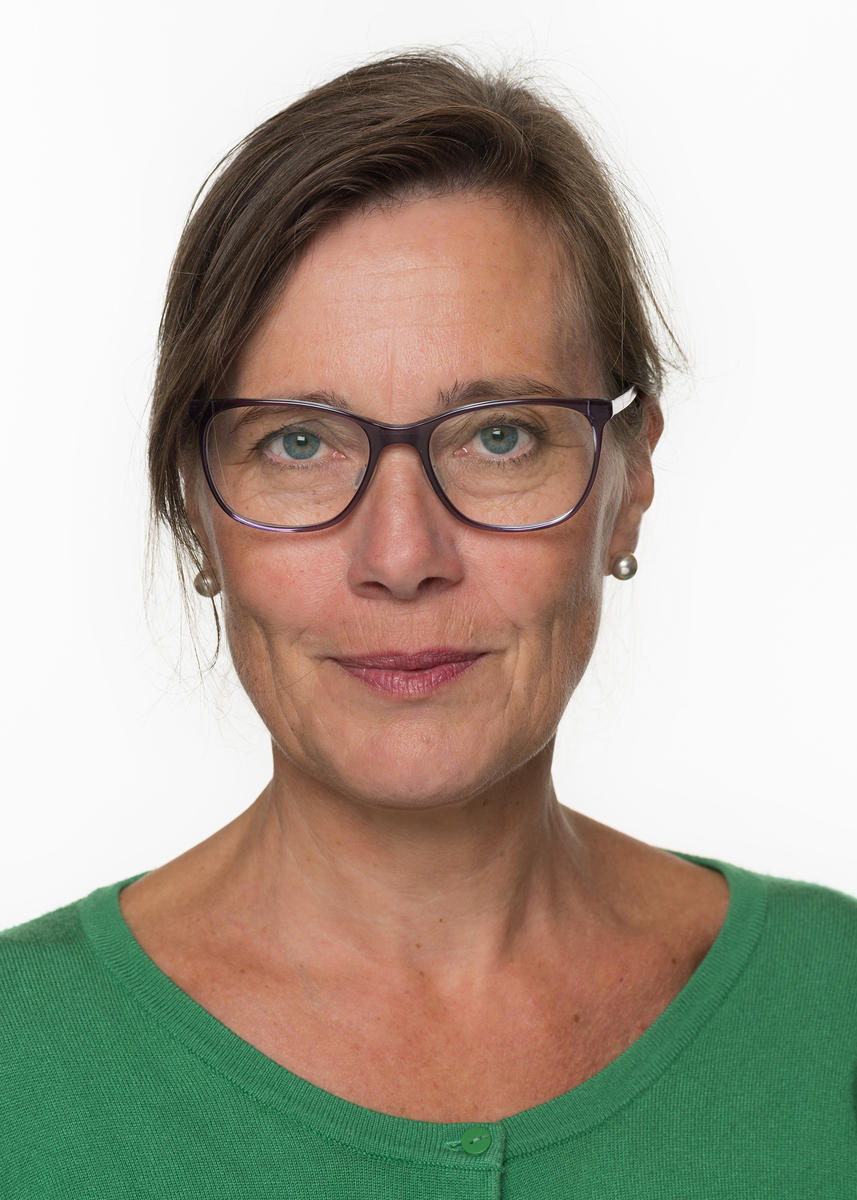 Portrettbilde av en kvinne med brunt hår og briller.