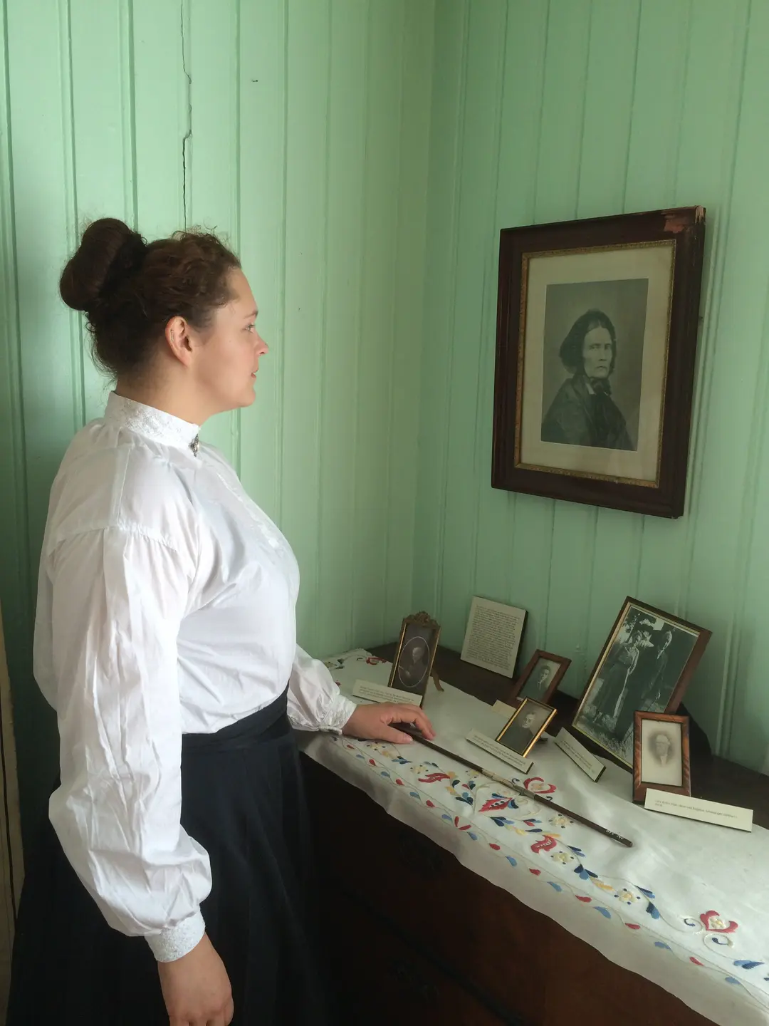 Maren Sofie Løfsgård som lærerinde ved Sagstuen skole beskuer portrettet av Mor Amble.