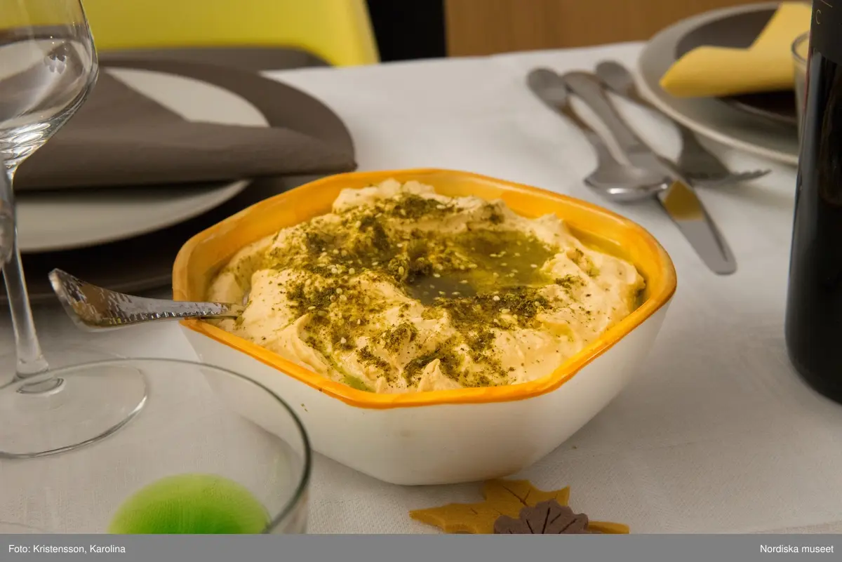 Rosh Hashana. Maten på ett judiskt nyårsbord: granatäpple, honung, bröd, äppelskivor, hummus, aubergine- och tomatröra, I köket: köttgryta (Hammin??) med sötpotatis, blomkål med citron, kycklingklubbor, ingefärssoppa, kryddris med linser och russin.