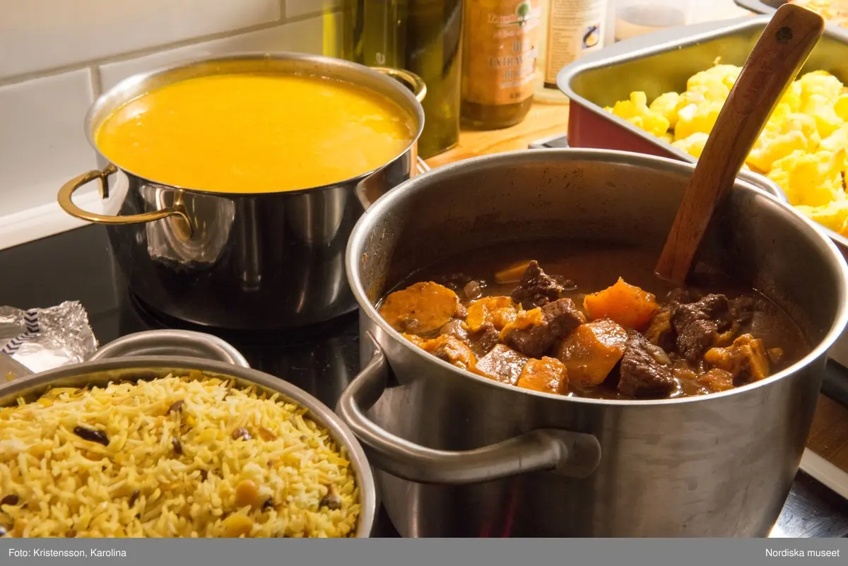 Rosh Hashana. Maten på ett judiskt nyårsbord: granatäpple, honung, bröd, äppelskivor, hummus, aubergine- och tomatröra, I köket: köttgryta (Hammin??) med sötpotatis, blomkål med citron, kycklingklubbor, ingefärssoppa, kryddris med linser och russin.