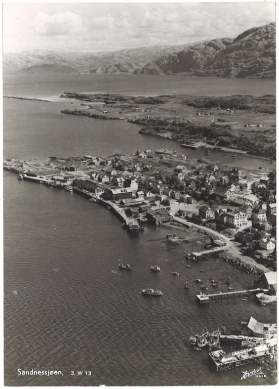 Svart/hvitt foto. Flyfoto av Sandnessjøen, fra vest, med horvnes bak.