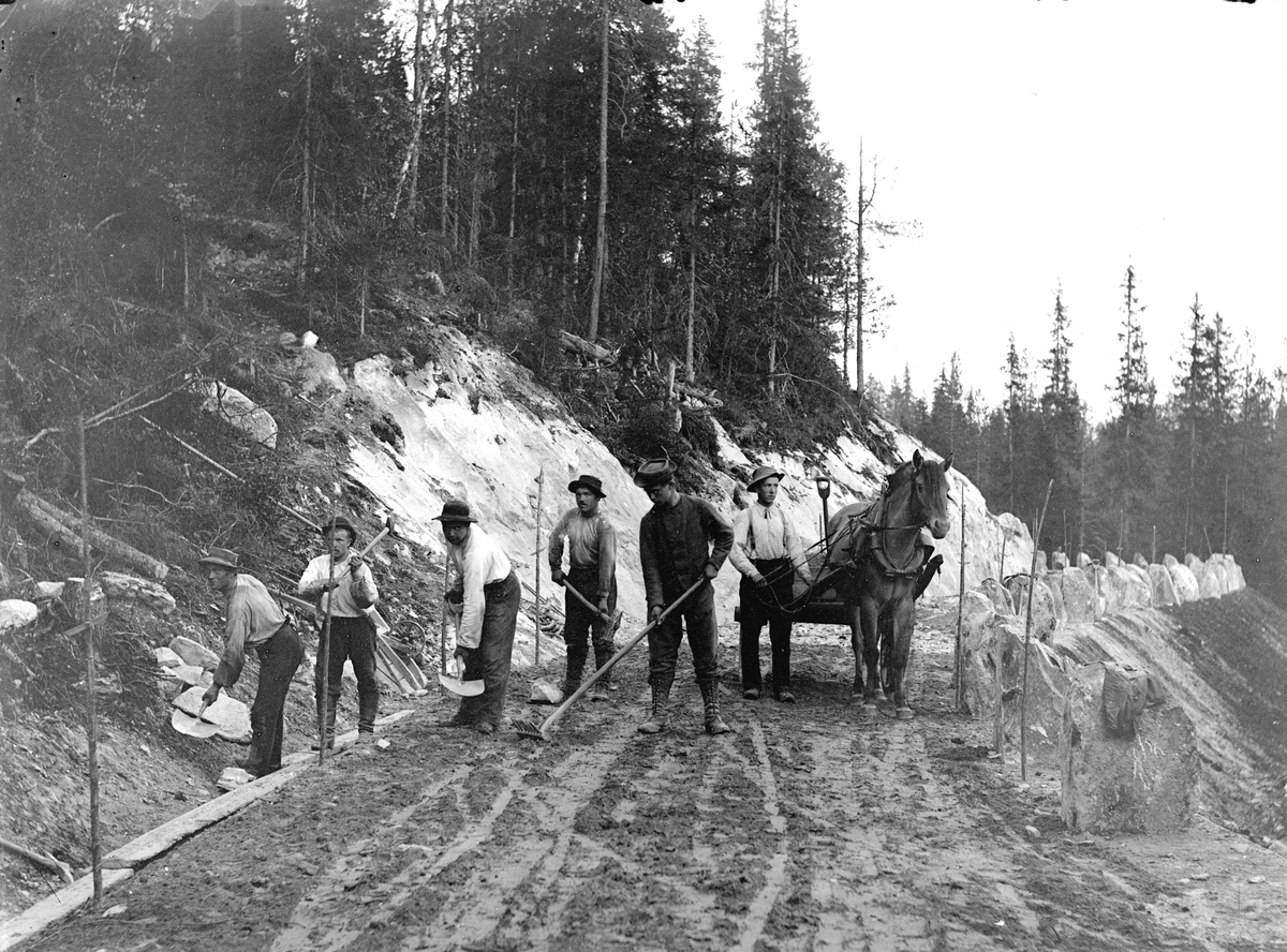 Dokumentasjon av arbeid med et veiprosjekt, ant i Trysil. Ukjente arbeidere. Vegbygging. Dessverre har vi ikke fått bekreftet opplysninger om hvilket prosjekt det er, men det kan være fra 1913, og bygging av vegen mellom Nybergsund og Innbygda.