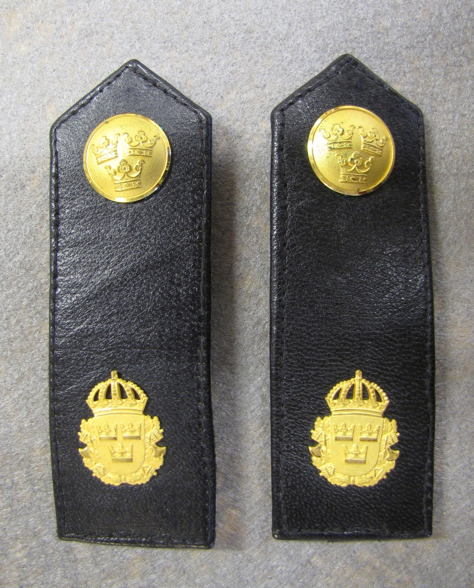 Axelklaff för polisuniform. Klaffen är för graden polisassistent.

Klaffen är försedd med knapp med tre kronor och lilla statsvapnet som är polisens emblem. Båda detaljerna i guldfärgad metall. 

Klaffen är helt klädd i läder. En rem finns på baksidan med en knapp i ena änden som håller klaffen på plats på uniformen.