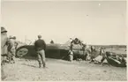 Havererat militärt skolflygplan SK 14 nummer 675, märkt F 5-175 på ett fält utanför Vittsäter, sydost om Nykil i Östergötland, den 30 april 1940. Män i närheten av flygplanet. Serie om 8 bilder.