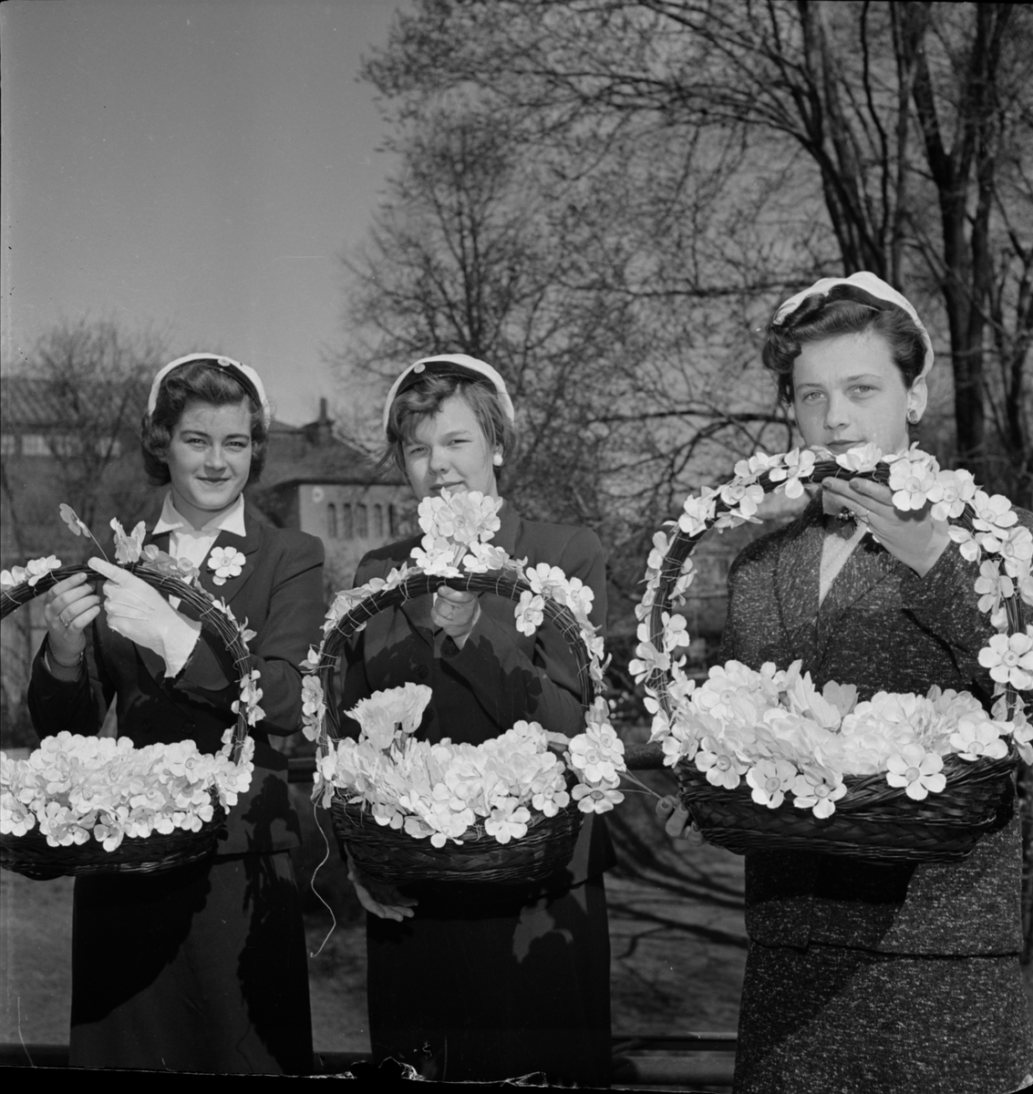 Kvinnliga studenter med vårfestblommor till Uppsala Studentkårs Vårfest i Botaniska trädgården, Uppsala 1956