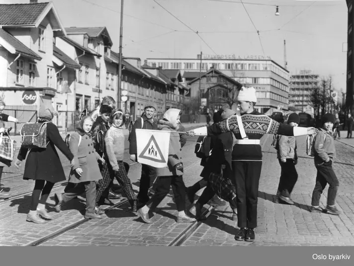 Skolepatruljen, gutt stopper trafikken, en flokk unger går over veien i krysset Helgesensgate - Trondheimsveien.