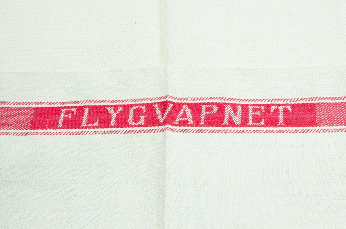 Linnehandduk med röda bårder. På lånsidorna är "Flygvapnet" invävt i bården.
