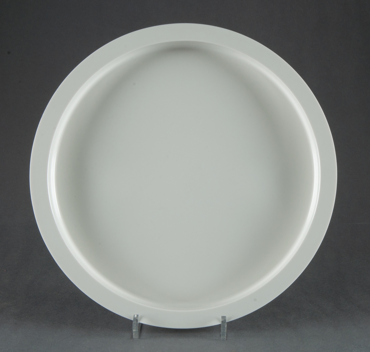 Tallrikar, gjutna i vit plast, 4 stycken. Modell "Plastic Medley". Helt flata med vertikala sidor, upptill avslutade med bred kant. Design Gunnar Cyrén. Tillverkad för Dansk Designs Ltd, USA.