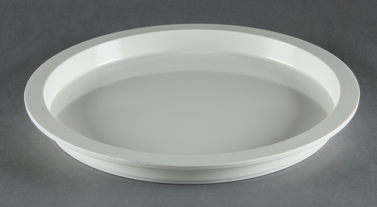 Tallrikar, gjutna i vit plast, 4 stycken. Modell "Plastic Medley". Helt flata med vertikala sidor, upptill avslutade med bred kant. Design Gunnar Cyrén. Tillverkad för Dansk Designs Ltd, USA.