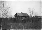 Män och kvinnor på vägen framför bostadshus , Östhammar, Uppland