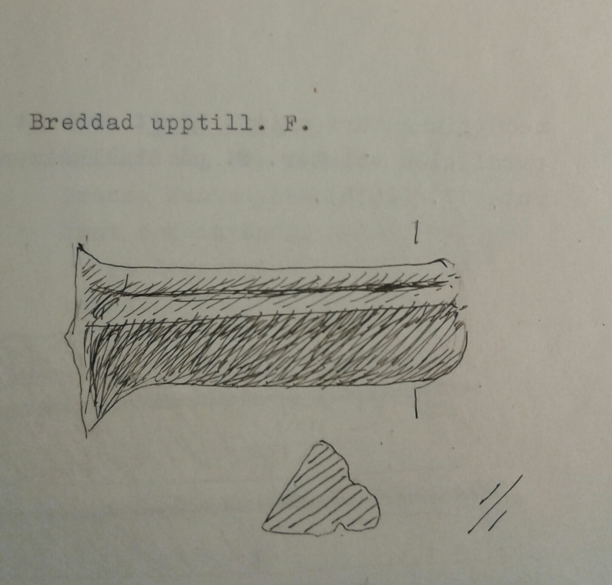 Grytfot av brons med triangulärt tvärsnitt. Breddad upptill mot grytans buk.