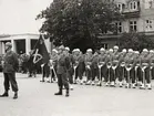 Militärer i uppställning framför konserthuset. Alla bär vita paradhjälmar med tillhörande uniform.