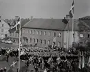 Uniformsklädda flottister står uppställda framför gamla posthuset vid Stortorget i Karlskrona.