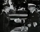 Konteramiral Samuelson överlämnar en pokal till en lotta. Båda är klädda i uniform.