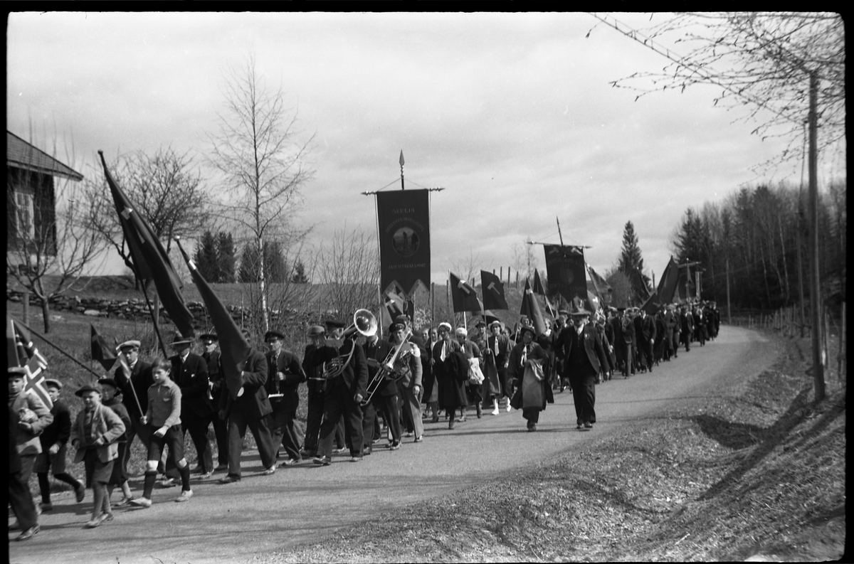 1.mai 1938 i Østre Toten. Demonstrasjonstog på daværende R.v. 33, mellom Hoff Arbeidersamfunn og Festivitetslokalet.
Serie på 11 bilder.