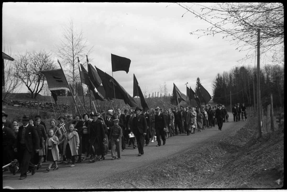 1.mai 1938 i Østre Toten. Demonstrasjonstog på daværende R.v. 33, mellom Hoff Arbeidersamfunn og Festivitetslokalet.
Serie på 11 bilder.