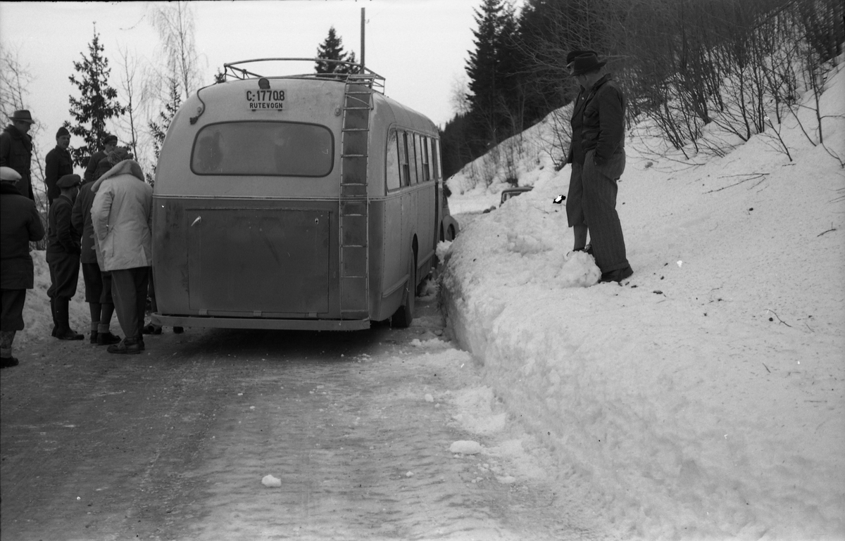 Møteuhell mellom buss og personbil på en trang Rv. 33 ytterst i Totenvika en vinterdag 1950. Bussen er "Eidsvollruta", bussen som gikk mellom Skreia og Eidsvoll. Serie på ni bilder.