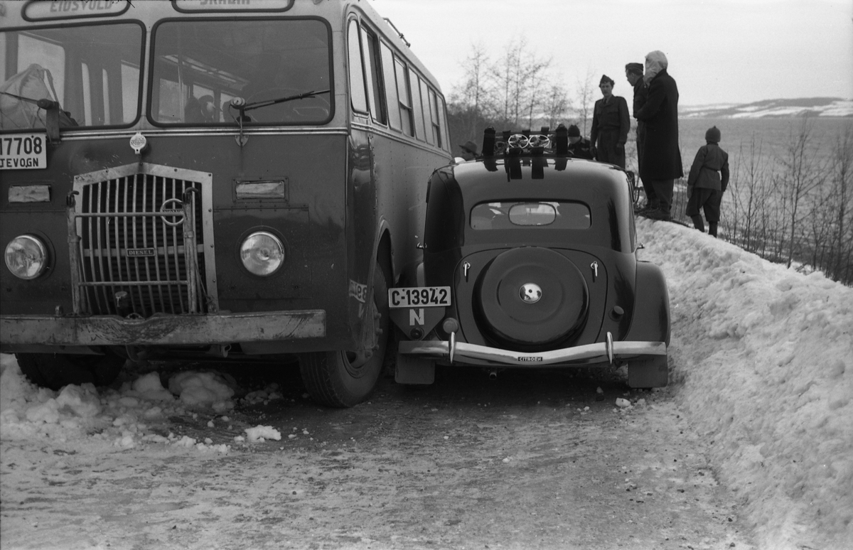 Møteuhell mellom buss og personbil på en trang Rv. 33 ytterst i Totenvika en vinterdag 1950. Bussen er "Eidsvollruta", bussen som gikk mellom Skreia og Eidsvoll. Serie på ni bilder.