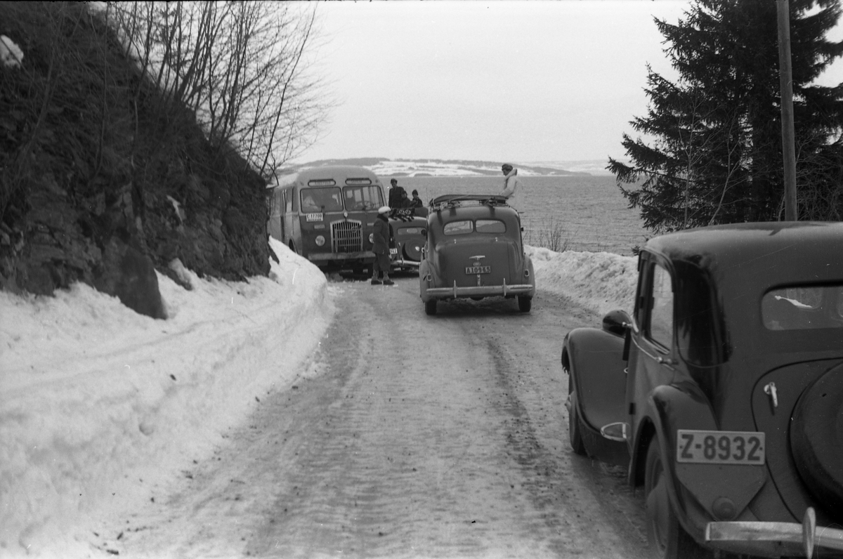Møteuhell mellom buss og personbil på en trang Rv. 33 ytterst i Totenvika en vinterdag 1950. Bussen er "Eidsvollruta", bussen som gikk mellom Skreia og Eidsvoll. Serie på ni bilder.