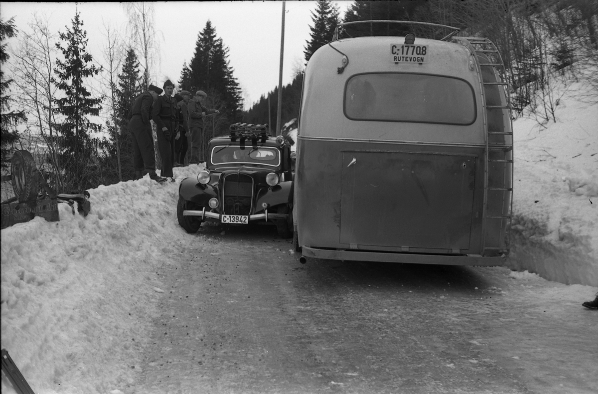 Møteuhell mellom buss og personbil på en trang Rv. 33 ytterst i Totenvika en vinterdag 1950. Bussen er "Eidsvollruta", bussen som gikk mellom Skreia og Eidsvoll. Serie på ni bilder.
