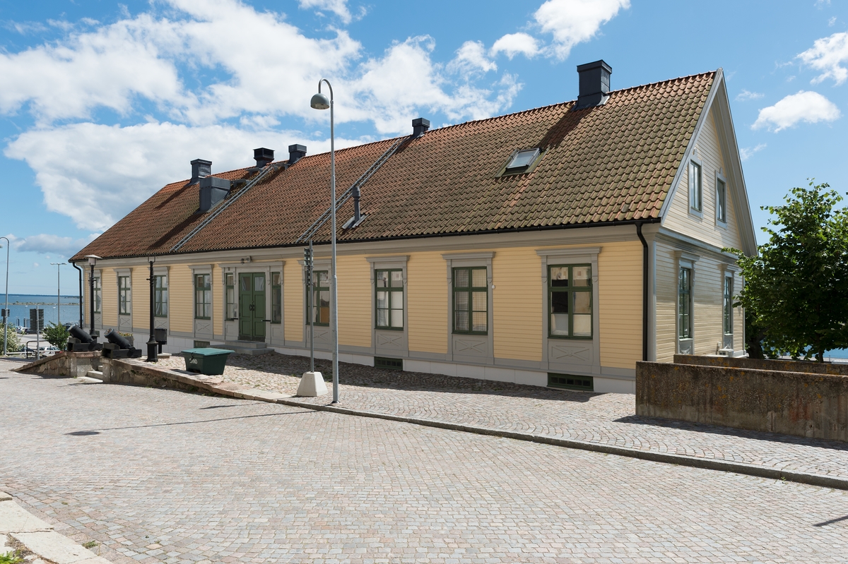 Suterränghus i en våning med källare och inredd vind. Fasad i liggande gul träpanel och sadeltak.