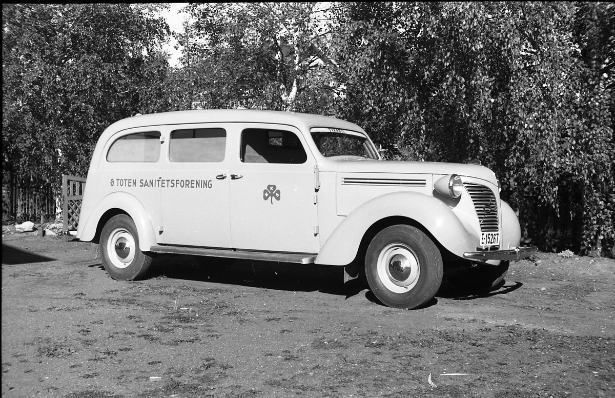 Ambulanse, muligens den første anskaffet av Østre Toten Sanitetsforening. Serie på 12 bilder fra september 1948. Kvinnen på bilde nr. åtte er Gjertrud Solem som trolig er sanitetsforeningens representant, mens mannen på bilde nr. sju, og som nok er sjåføren, er Anders Skolby fra Kapp. Han ble senere sjåfør for kronsprins Olav på Skaugum, og etter det privatsjåfør for Anders Jahre .