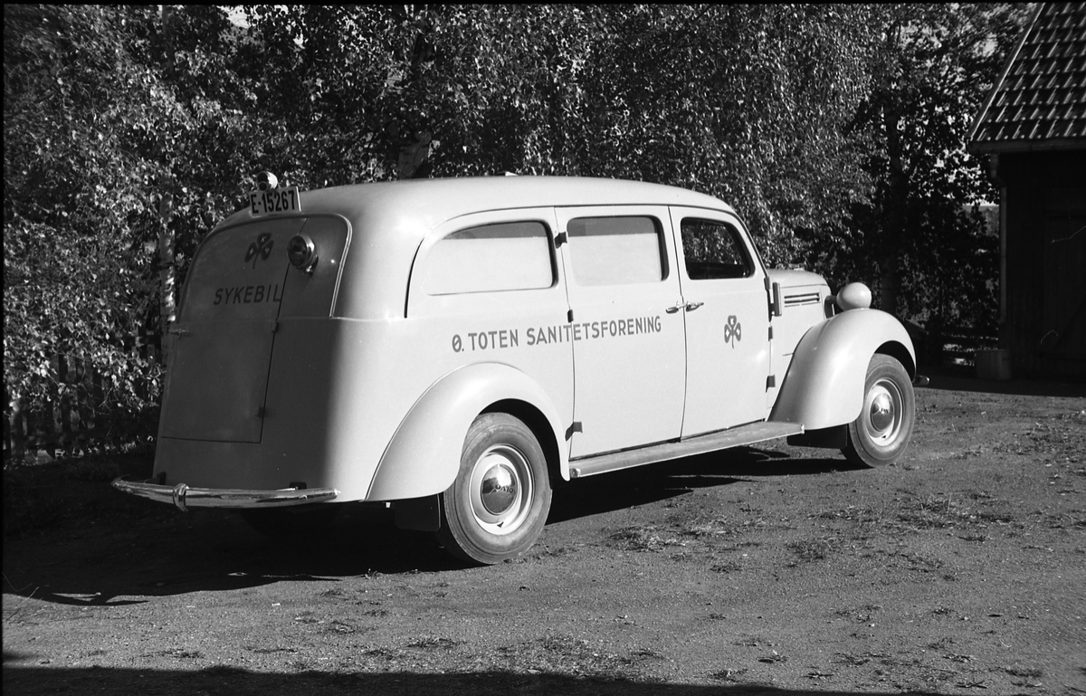 Ambulanse, muligens den første anskaffet av Østre Toten Sanitetsforening. Serie på 12 bilder fra september 1948. Kvinnen på bilde nr. åtte er Gjertrud Solem som trolig er sanitetsforeningens representant, mens mannen på bilde nr. sju, og som nok er sjåføren, er Anders Skolby fra Kapp. Han ble senere sjåfør for kronsprins Olav på Skaugum, og etter det privatsjåfør for Anders Jahre .
