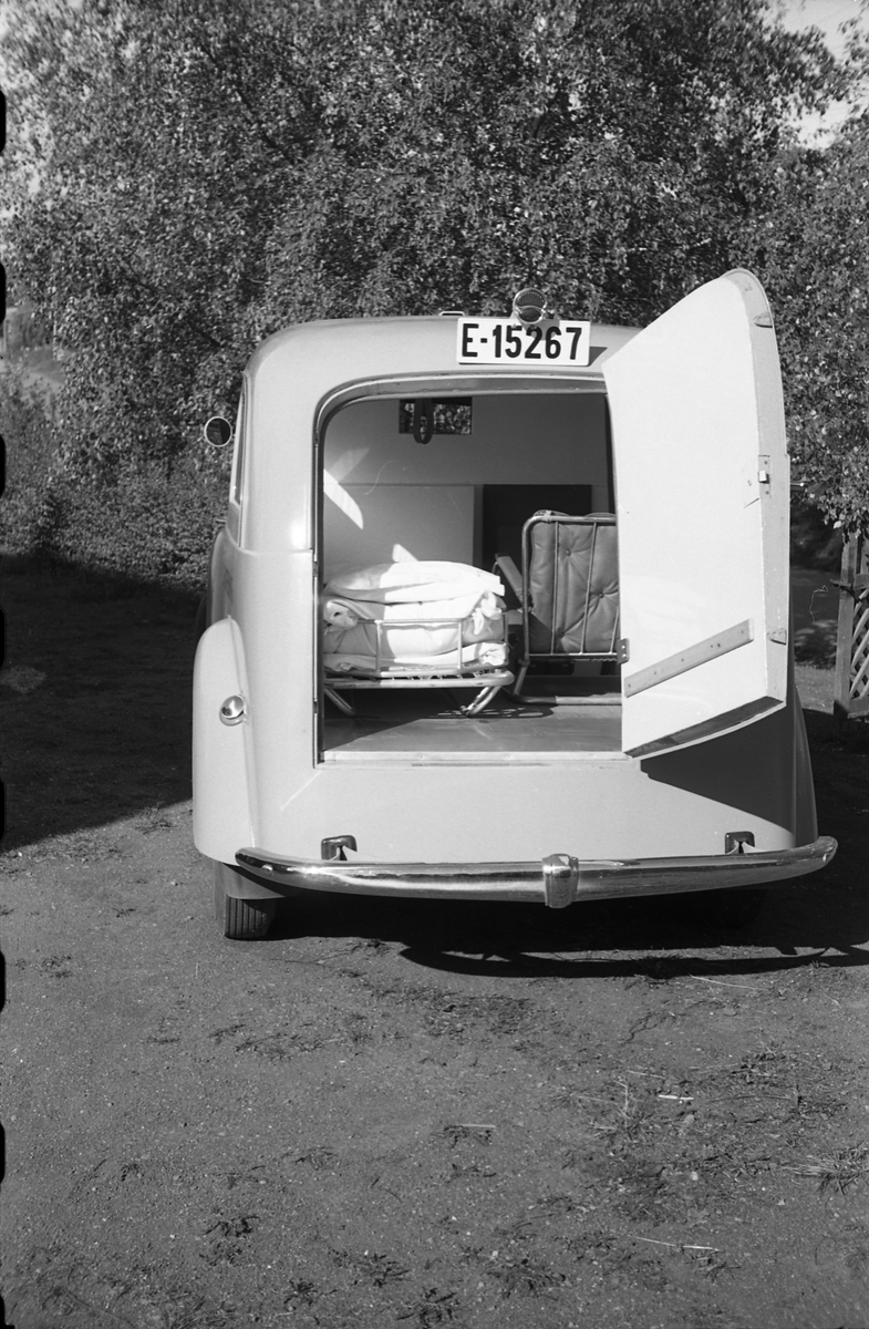 Ambulanse, muligens den første anskaffet av Østre Toten Sanitetsforening. Serie på 12 bilder fra september 1948. Kvinnen på bilde nr. åtte er Gjertrud Solem som trolig er sanitetsforeningens representant, mens mannen på bilde nr. sju, og som nok er sjåføren, er Anders Skolby fra Kapp. Han ble senere sjåfør for kronsprins Olav på Skaugum, og etter det privatsjåfør for Anders Jahre .