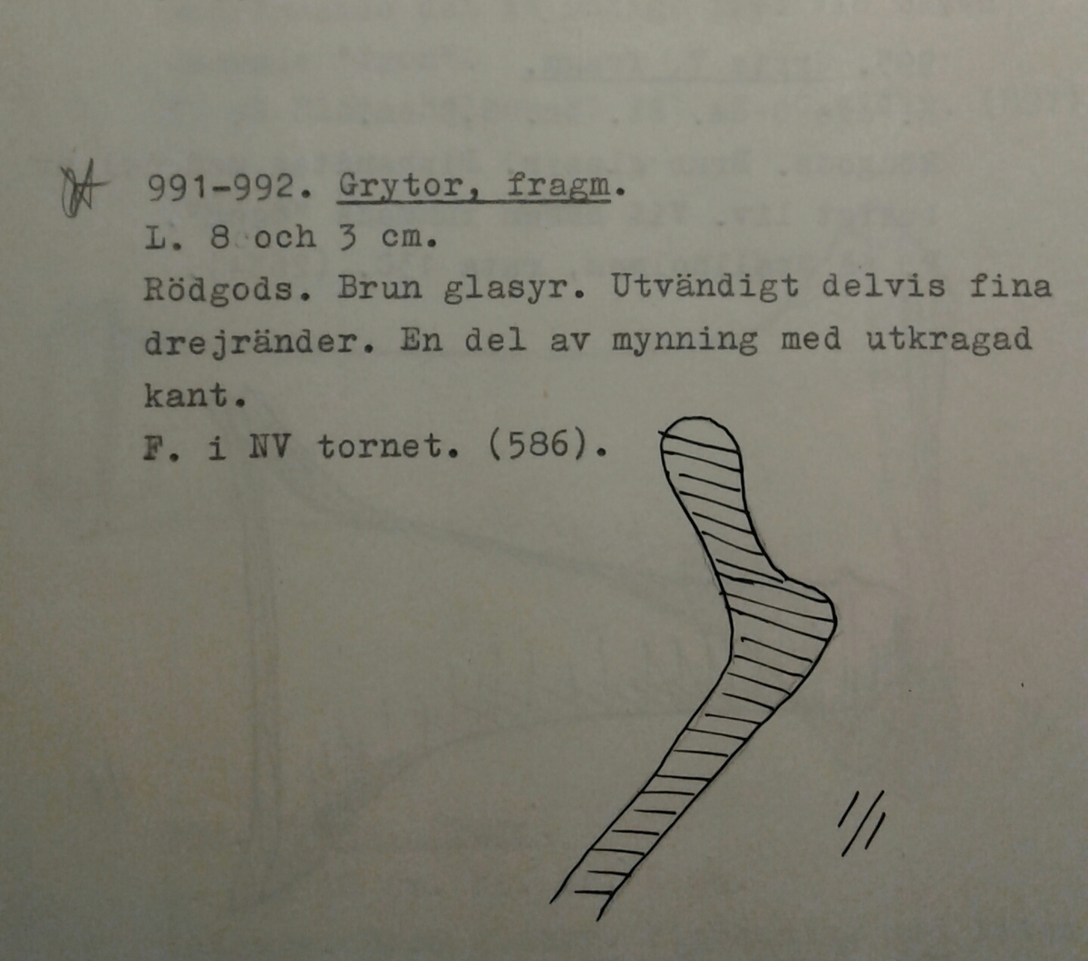 Fragment av mynning till ett keramikkärl, möjligen en trefotsgryta. Mynningen är av yngre rödgods och har en utkragad kant, samt utvändiga drejlinjer. Brun glasyr på kärlets insida. Tillverkad i södra Skandinavien.