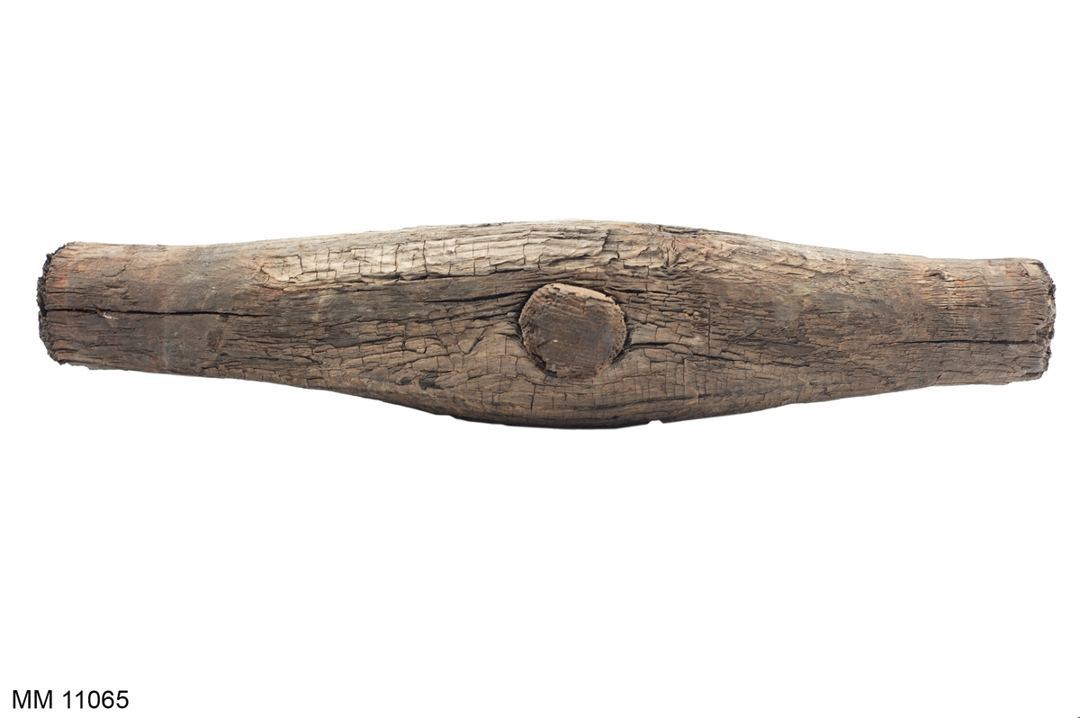 Drevhammare av trä. Hammaren tillverkad under år 1708. Bågformad, på mitten försedd med genomgående runt träskaft. Nitar vid skaft och ringar kring slagen saknas (är sönderrostade).