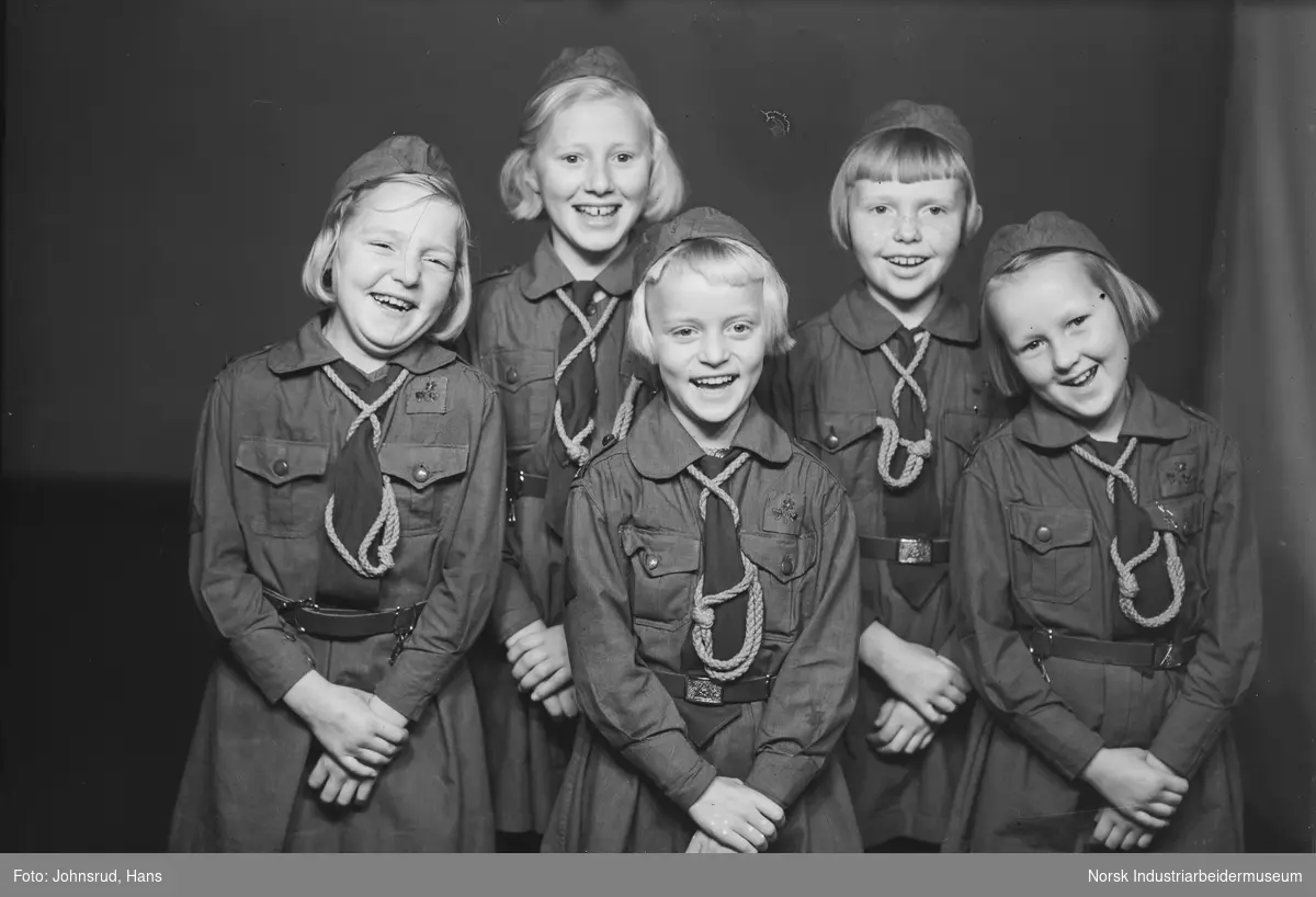 Speiderjenter i uniform med slips og lue.