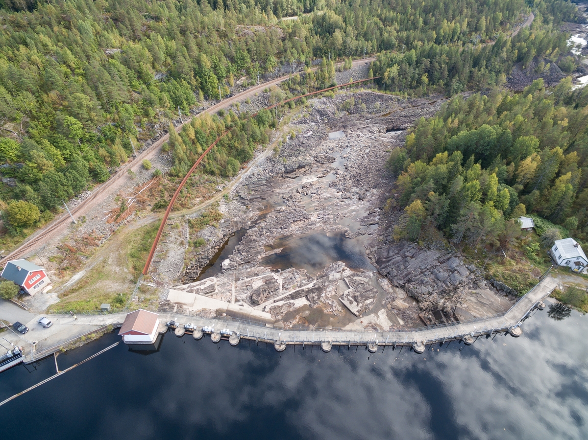 Haugsjå dam. Haugsjådammen sett oppstrøms, den er 160 meter lang. Langs det tørre elveleiet nedstrøms dammen går Arendalsbanen på venstre side, mellom jernbanen og elveleiet ser ein tømmerrenna. Sett mot SØ.