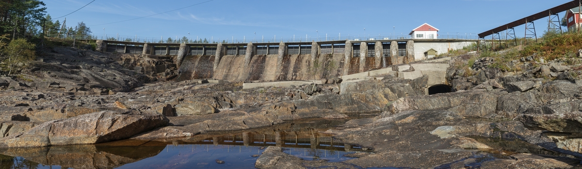 Haugsjå dam, nedstrøms. Panoramafoto av Haugsjådammen, dammen er 160 meter lang og 16 meter høg på høgaste og består av 19 luker, opprinnelig var dammen ein nåledam. Den har opp gjennom åra gått gjennom fleire oppgraderingar og no skal flomlukene støypast igjen i samband med planlagt oppgradering for å gjera dammen enda meir stabil. Sett mot NV.