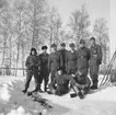 Grupporträtt. Jaktflygförare vid Svenska frivilligkåren i Finland, F 19, utomhus.

Främre raden, sittande från vänster: Arne Frykholm, Carl-Olof Steninger. Bakre raden: Martin Wennerström, Åke Nettelbladt-Hollsten, Ian Iacobi, Roland Martin, Hans Olof Palme, Per-Johan Salwén samt Gideon Karlsson.