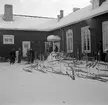 Skidparkering vid förläggning på F 19, Svenska frivilligkåren i Finland. En samling militärer vid huset.