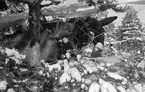 Flygplan Hawker Hart märkt svart M vid F 19, Svenska frivilligkåren i Finland, förbereds för bombanfall. En flygtekniker i arbete vid flygplanet, vilket är kamouflerat i terräng.