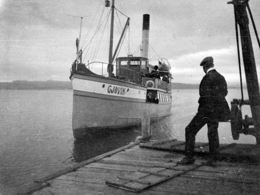 D. S. Gjøvik ved Sundsbrygga, Helgøya. Mjøsbåt. Mann tar i mot. Heisekran på brygga.