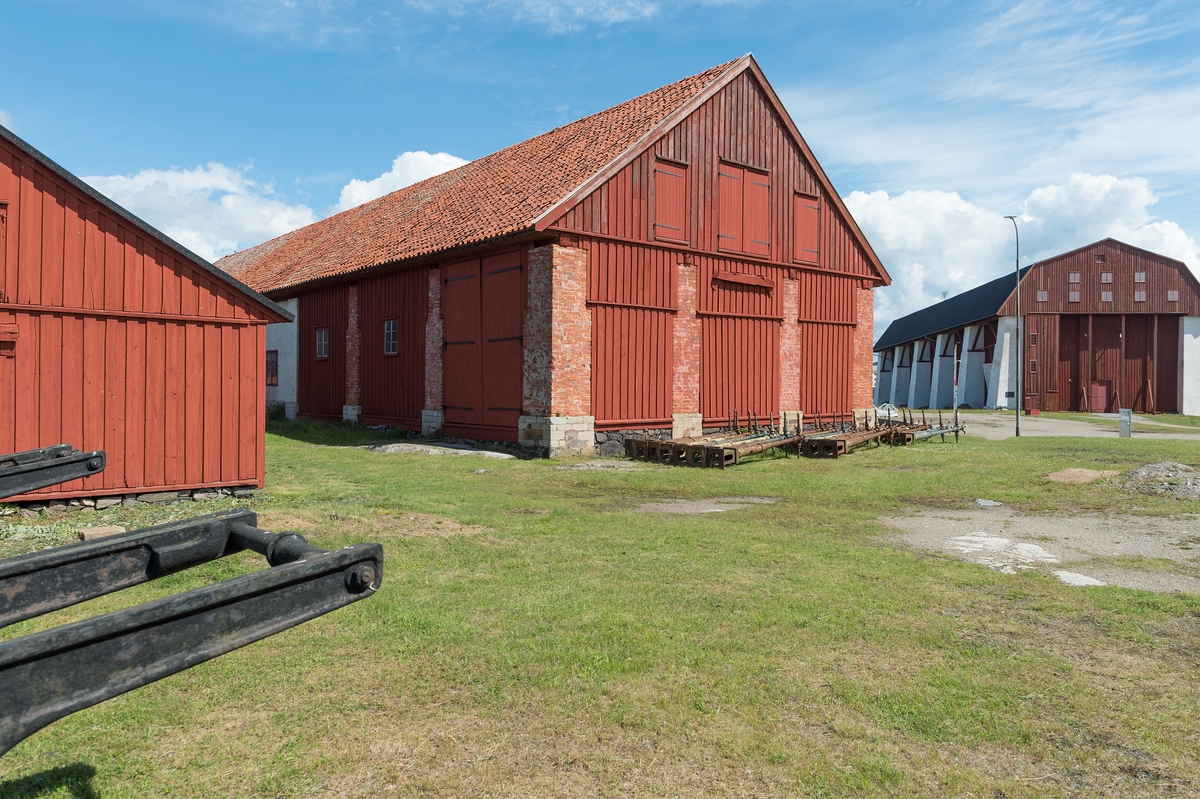 Fotodokumentation av byggnader på Lindholmen i Karlskrona.  Till vänster: Virkesskjul.  Mitten: Granknäskjulet eller senare benämning knäskjulet. I denna byggnad handskades det med "knä" det var naturvuxna krokiga detaljer som användes vid skeppsbyggandet. Till höger: Stora skeppsskjulet uppfördes på 1760-talet och benämdes senare (1778) som Vasa skjul. Byggnaden fungerade som klimatskydd över stapelbädden. Ritningar av byggnaden från 1759 är signerade av arkitekt C J Cronstedt.