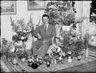 Man i hemmiljö omgiven av blommor, Östhammar, Uppland