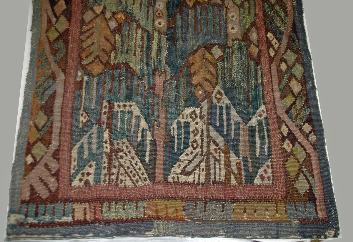 Väv/gobelin "Granen vid badstället" komponerad av Märta Måås-Fjetterström. Delvis nött. Denna nästan 2 meter höga gobeläng komponerade Märta Måås-Fjetterström år 1918 som gåva till sin vän och arbetsgivare vid Vittsjö vävskola Lilli Zickerman på hennes 60-årsdag. Med stor sannolikhet är den utförd av Märta Måås-Fjetterström själv. Till föremålet finns även en skiss i akvarell, GM42723.