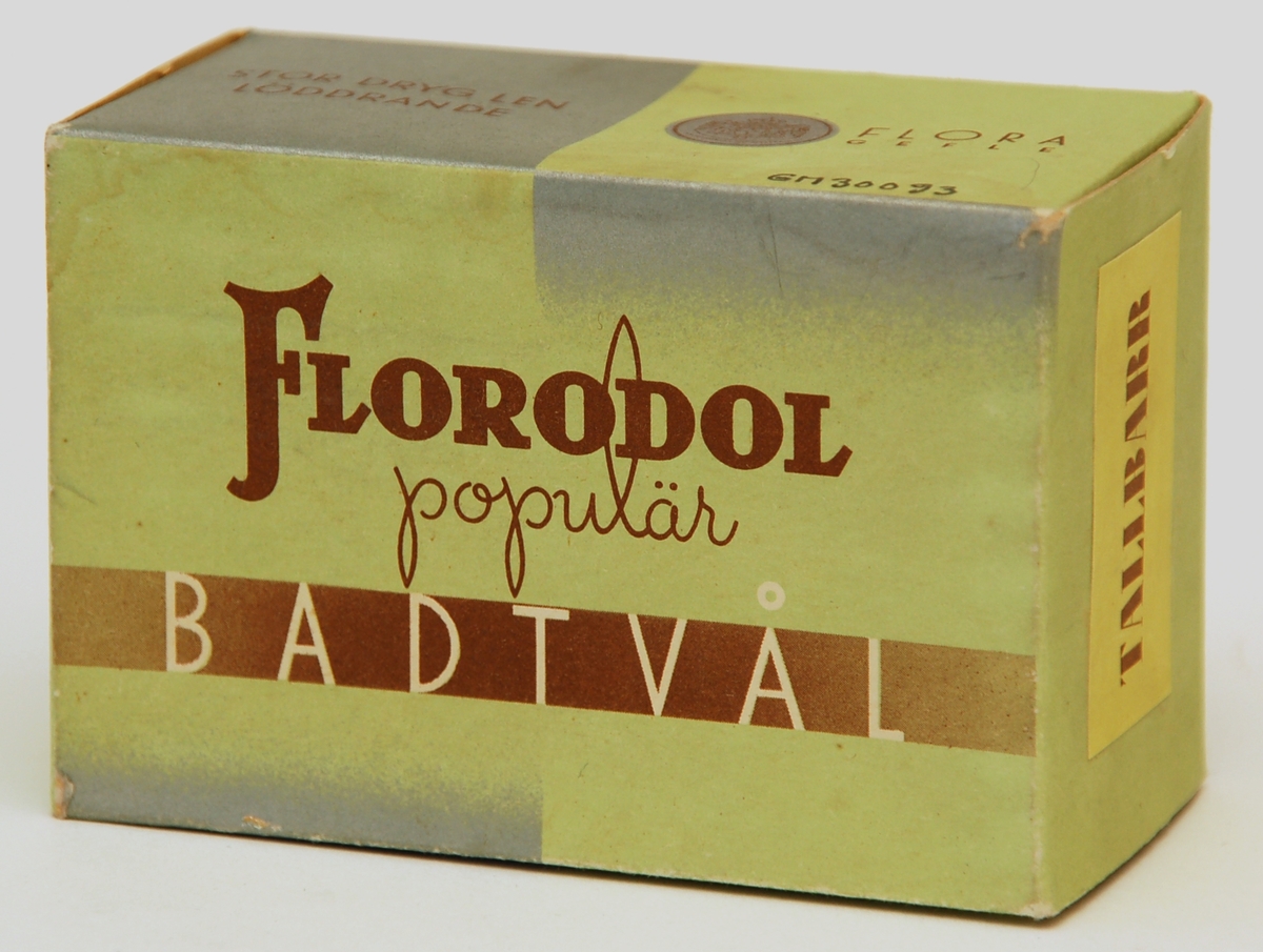 Tvålförpackning av papp. Rektangulär ask med tryck i brunt och silver på ljusgrön grund. Text: "Florodol populär BADTVÅL" och "FLORA GEFLE" samt "TALLBARR" m.m.