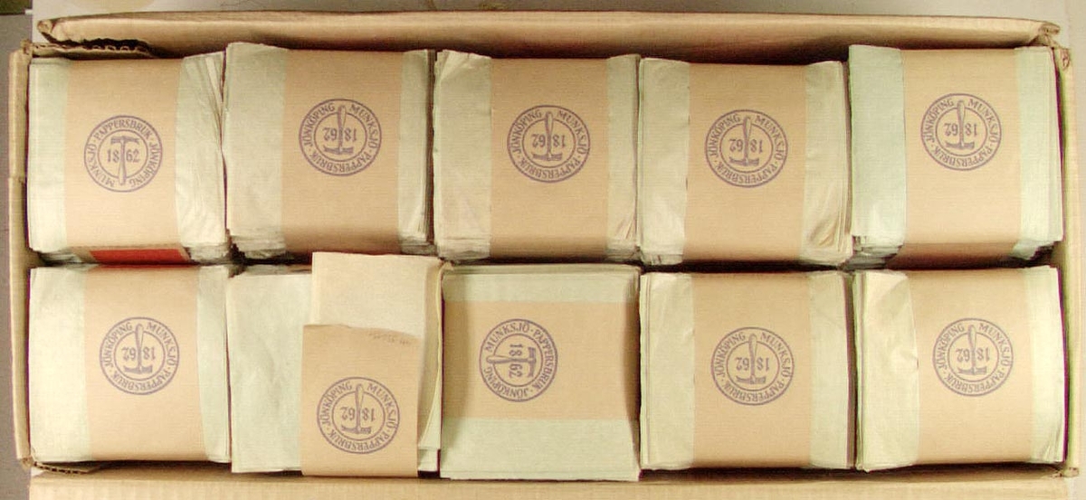 10 st förpackningar av toalettpapper i form av vikta blad (industriförpackning). Papperen är ljust gröna och i buntar om 2000 ark. På gördeln runt om finns anvisning om hur papperen lösgöres ur gördeln. De 10 buntarna ligger i originalkartong märkt Munksjö dubbla. Tillverkade vid Munksjö Pappersbruk i Jönköping.