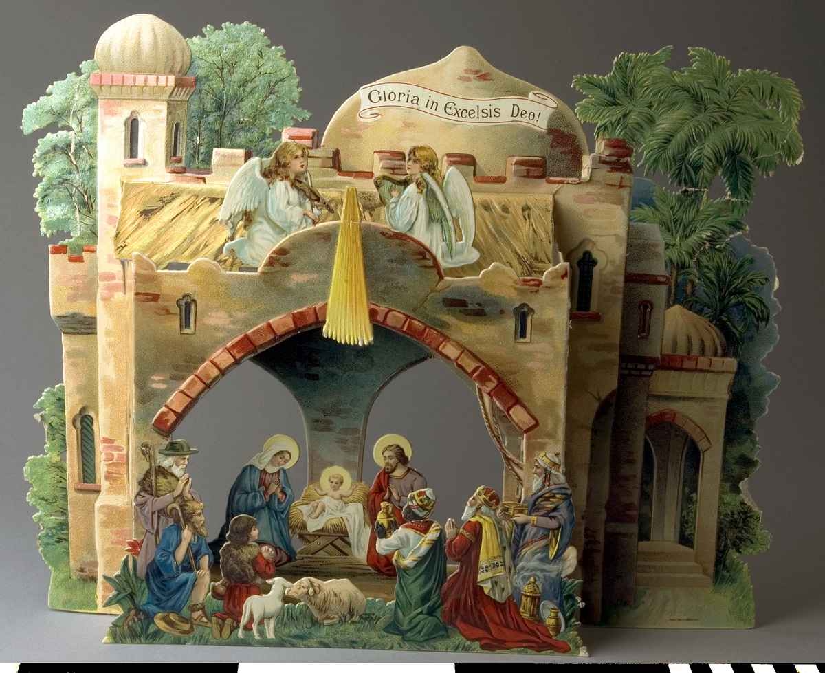 Julkrubba av papp, fabriksgjord. Krubban består av tre delar av motivtryckt  glansig papp i många färger, som fogas samman i djupled. Motivet är Jesu födelse i ett stall i Bethlehem, med herdar, änglar och de tre konungarna. Den bakersta delen har utskurna försteröppningar, försedda med röd cellofan. I det nedre högra hörnet tryckt: PRINTED IN GERMANY.

Stjärnan har fallit bort, endast dess strålar finns kvar. Nötta kanter och brytmärken, men annars i tämligen gott skick.