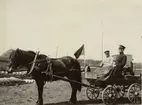 Två män på vagn dragen av häst.
Finnvikskabeln. Dynamittransport. Ur albumet Kabelarbetet Hjälmsälra (Hjälmsättra) - Norrtälje -  Finnviken utfört under sommaren 1928.