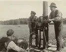 Tre män i arbete.
Hjälmsätrakabeln. Vinsch för kabeldragning. Ur albumet Kabelarbetet. Hjälmsälra - Norrtälje - Finnviken utfört under sommaren 1928. 
 

Hjälmsätrakabeln. Påhankning. Utföres av Lf. Kjällströms lag. Block för kabeldragning vinkel från stolpen. Ur albumet Kabelarbetet. Hjälmsälra - Norrtälje - Finnviken utfört under sommaren 1928.