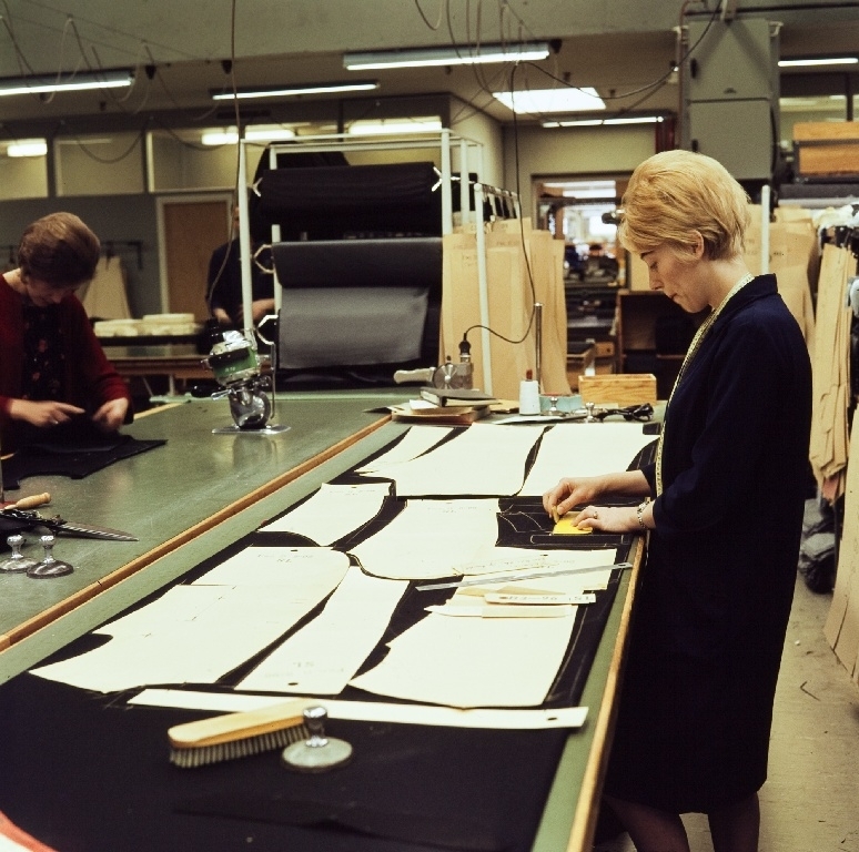 Ansatt i konfeksjonsfabrikken til Jonas Øglænd Sandnes påtegner mønster-sjablonger på stoffet før tilskjæring.