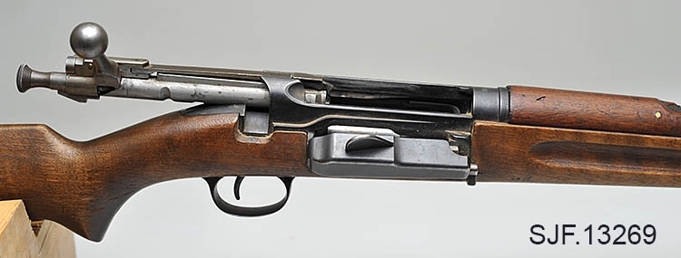 Krag-Jørgensen rifle med kaliber 6, 5 x 55. Geværet har pistolgrep. Magasinkapasitet på 5 patroner. Kolben er brunbeiset / oljet. Kolbekappe av stål. På munningen er det festet ei messinghette, en snø- og vannbeskytter. Geværet er utstyrt med høydejusterbart skur og sidejusterbart korn. 
Det er bærereim påmontert geværet. 